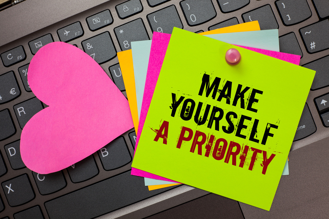 Text sign showing Make Yourself A Priority. Conceptual photo Think in your own good first personal development Bright colorful written papers pinch by pin pink heart on computer keyboard.